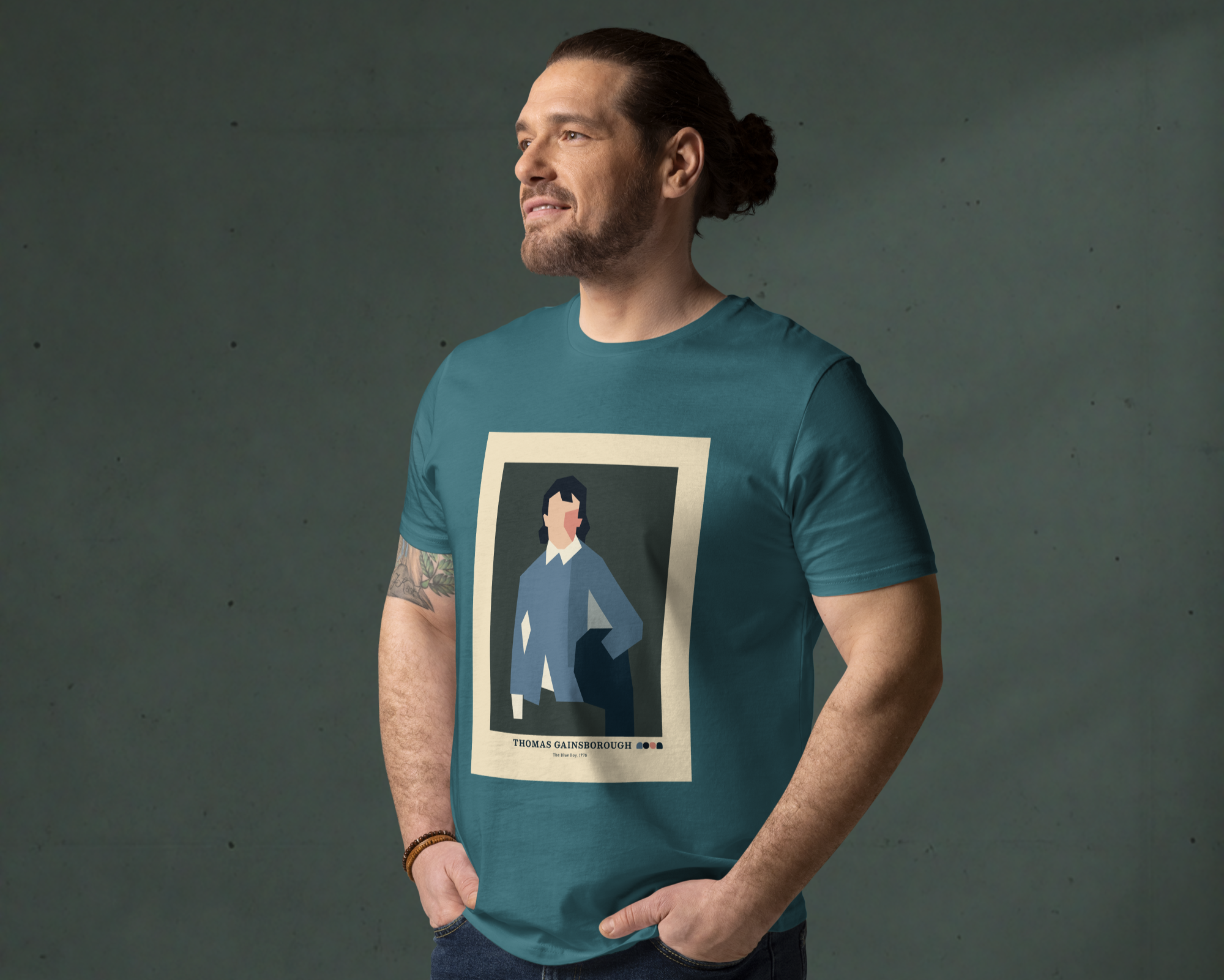 Man wearing a teal t-shirt with a Studio Noon geometric art printed design, on a dark background